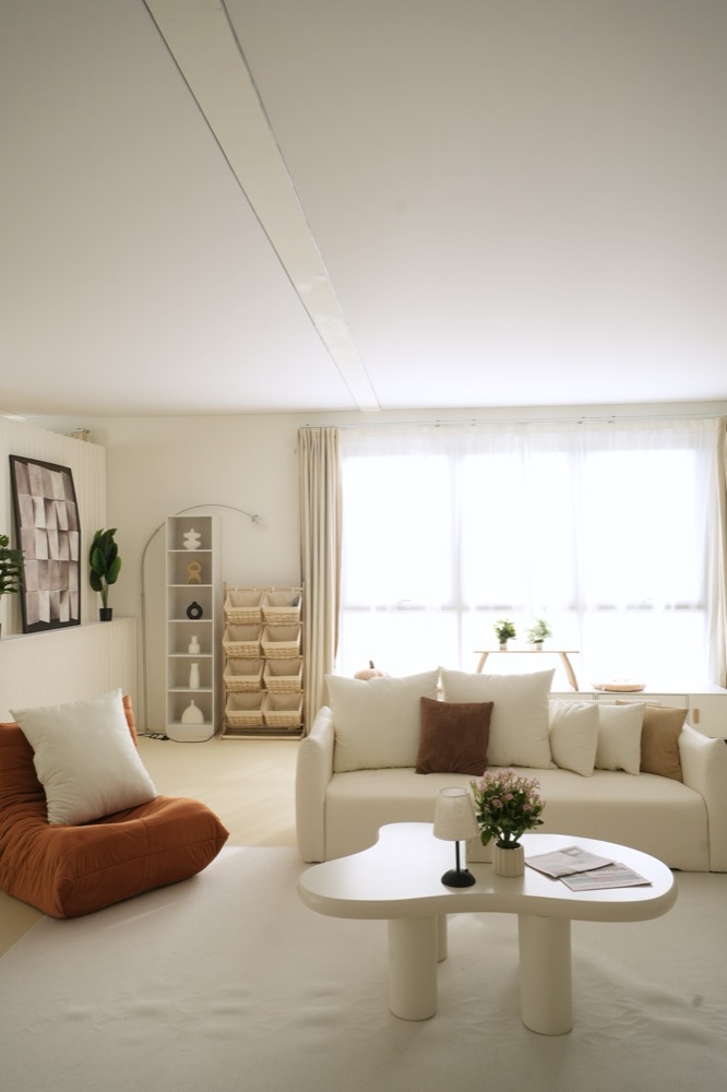 Cream sofa and cloud coffee table in front of large sheer windows