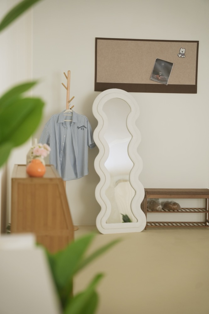 Wavy standing mirror, hanging shirt and pinboard
