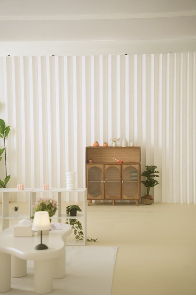 Movable fluted wall panel with an oak cabinet and plants